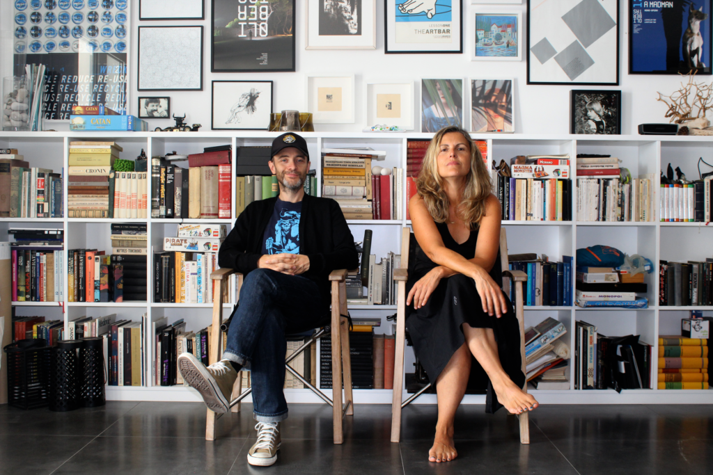 the openny black remedy sat on chairs against a backdrop of book shelves