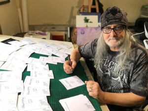 rodney matthews signing the card for the colouring book