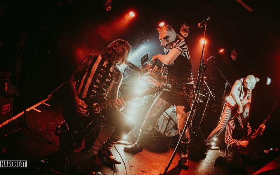 Ward XVI on stage with actors dressed as raboid animals and a chainsaw